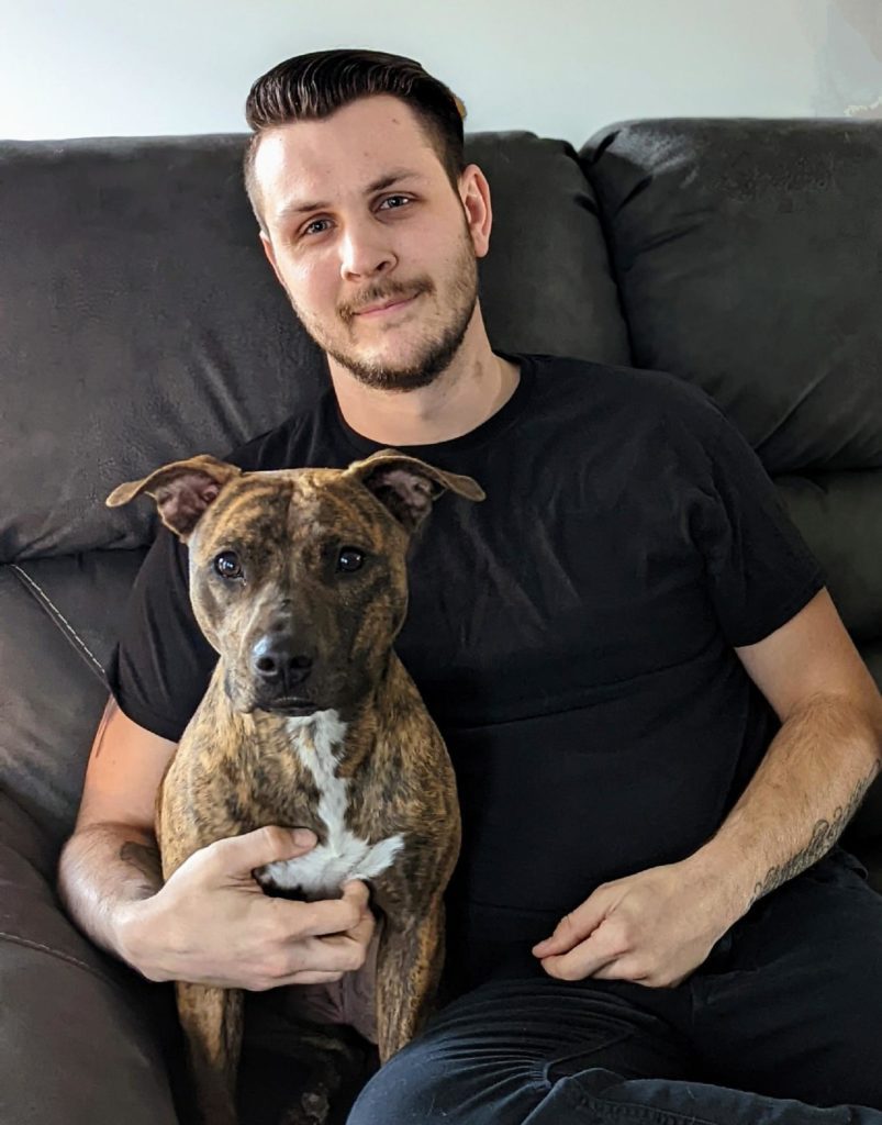 Man posing with a dog.